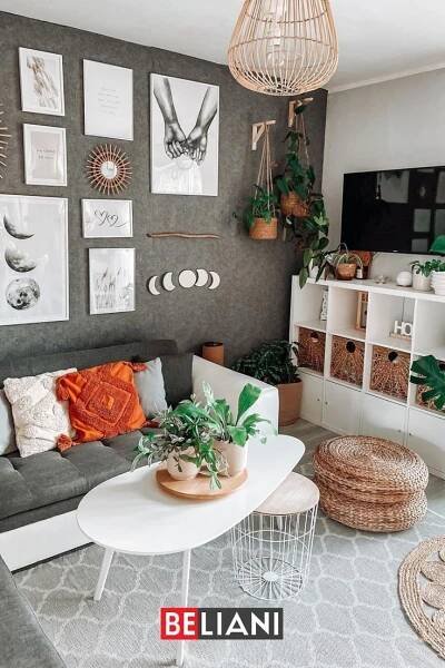 a living room filled with lots of plants and pictures on the wall above it's coffee table