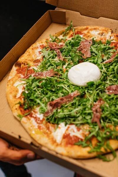 Opened to-go box of pizza with pizza inside