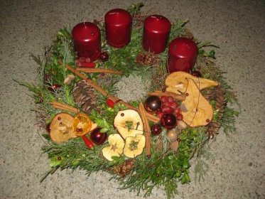 a christmas wreath with apples, cinnamons and pine cones on the floor ...