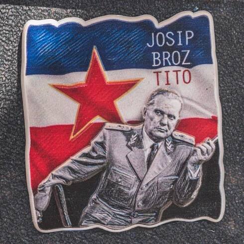 Bezplatný obrázek: Josip Broz Tito, Socialistická federativní republika Jugoslávie, fotografie bývalého prezidenta ve vojenské uniformě s vlajkou Jugoslávie v pozadí