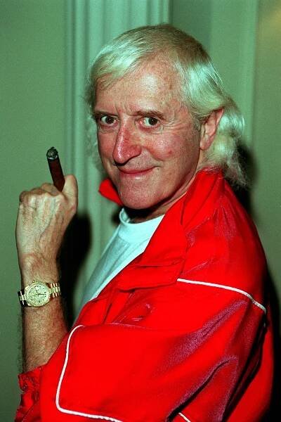 Photo of Jimmy Savile holding a cigar.