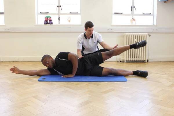 Progressive hip abductor strengthening exercises supervised by specialist MSK therapist