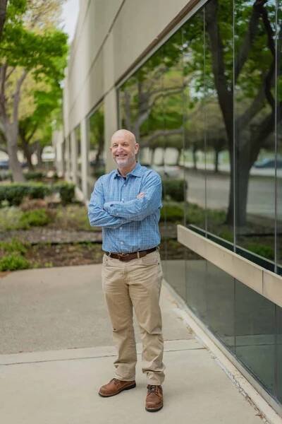 A man standing in front of an office building.