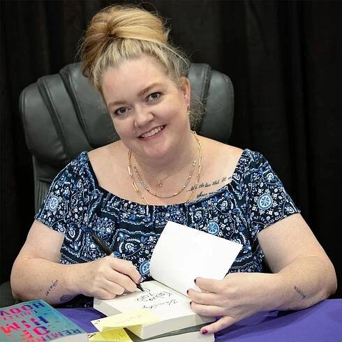 Colleen Hoover signing books.