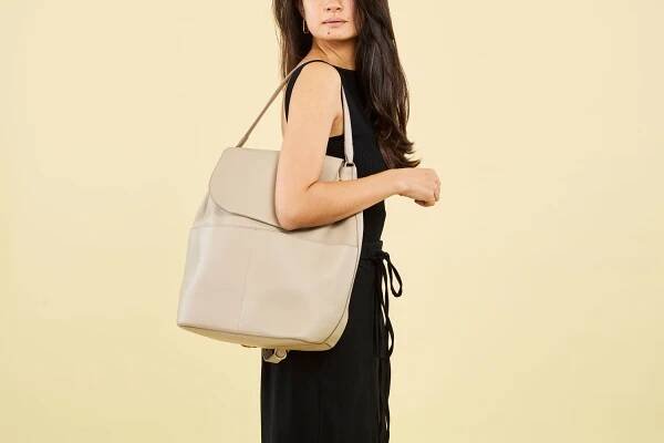 Woman wearing cuyana leather backpack over the shoulder.
