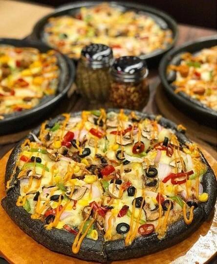 several pizzas with different toppings sitting on wooden platters