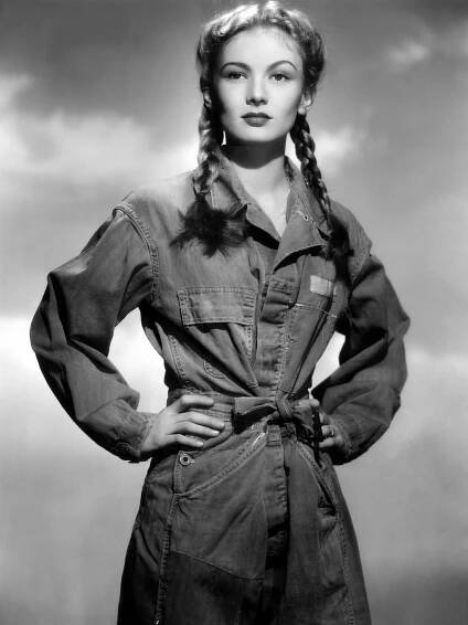 an old photo of a woman with braids on her hair and denim shirt dress