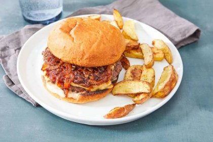 a caramelized onion burger on a plate with oven baked potato fries