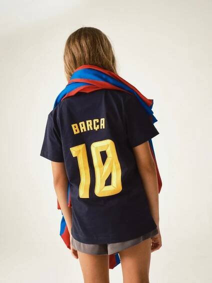 Back view of a navy FC Barcelona jersey with 'BARÇA' text and the number 10 printed in bold yellow.