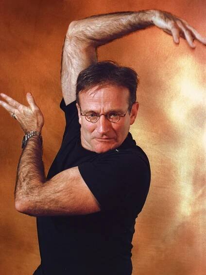 a man in black shirt and glasses holding his arms out with both hands while posing for the camera