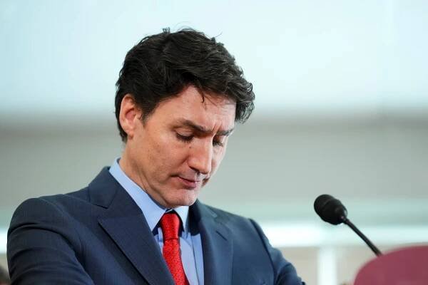 Justin Trudeau looking down at a microphone.