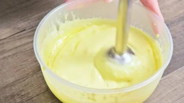 Detail, bičování domácí majonéza s mixérem v plastové misce — Stock záběr