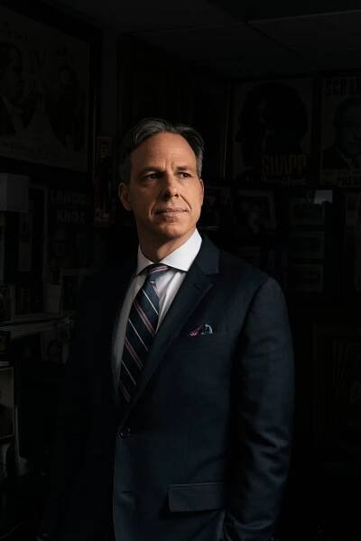 A portrait of Jake Tapper in a dark suit and striped tie.