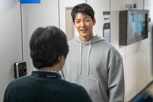 Kim Woo-bin as Lee Jeong-do faces Kim Sung-kyun as Kim Seon-min in the hallway of an office in an image from the film ‘Officer Black Belt.’