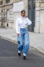 Person wearing cuffed baggy jeans with a white wrapped blouse and turtleneck