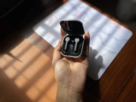 A photo of a person holding Amazon Echo buds