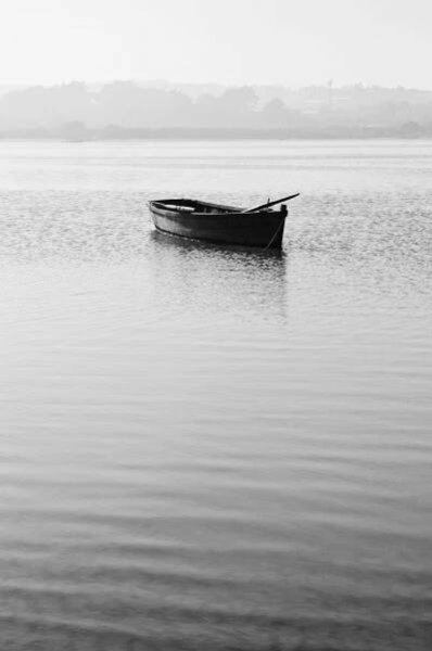 a small boat floating on top of a large body of water