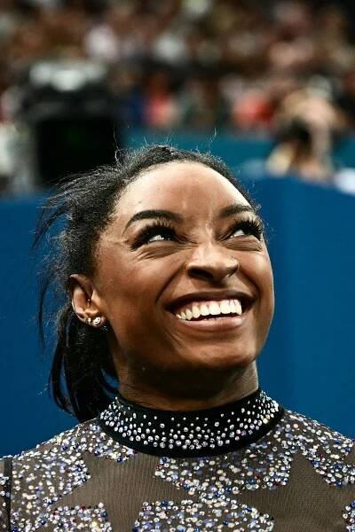 Image may contain Simone Biles Head Person Face Happy Smile Adult Laughing Accessories Jewelry and Necklace