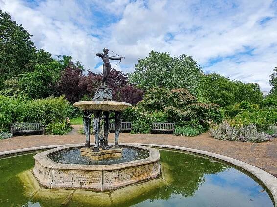 Statue of greek goddess with bow in the middle of a fountain in the rose garden at Hyde Park - the royal park has some fun family activities this Easter in London