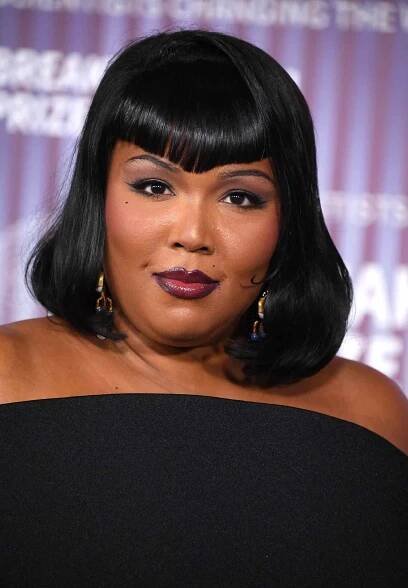 Lizzo wears winged eyeliner and dark cranberry lipstick