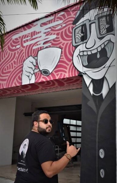 Jorge-Miguel Rodriguez poses in front of the newly completed mural. 