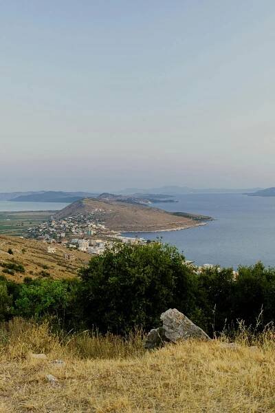 bezplatná Prozkoumejte klidnou krásu albánské Sarandë s touto úchvatnou pobřežní krajinou za soumraku. Základová fotografie