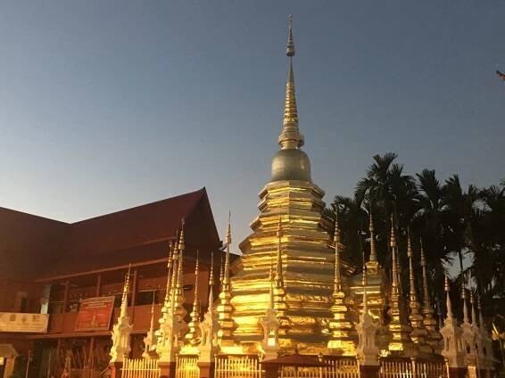 Photo of shining gold stupa at sunset Wat Phan Tao in Chiang Mai, Thailand