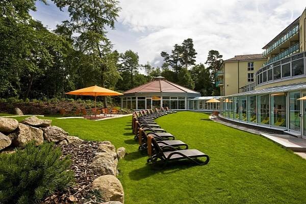 a row of chaise lounges on a lawn near a building at Dorint Seehotel Binz-Therme in Binz