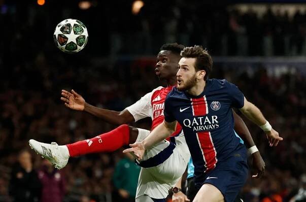 Arsenal's Bukayo Saka in action with Paris Saint-Germain's Khvicha Kvaratskhelia.