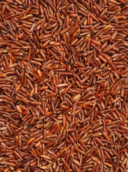 Close-up of a bunch of red rice grains, taken from overhead.