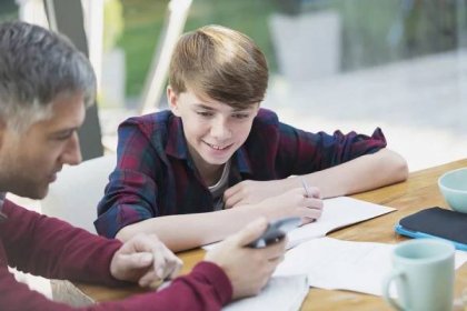 Father with calculator helping son with math homework