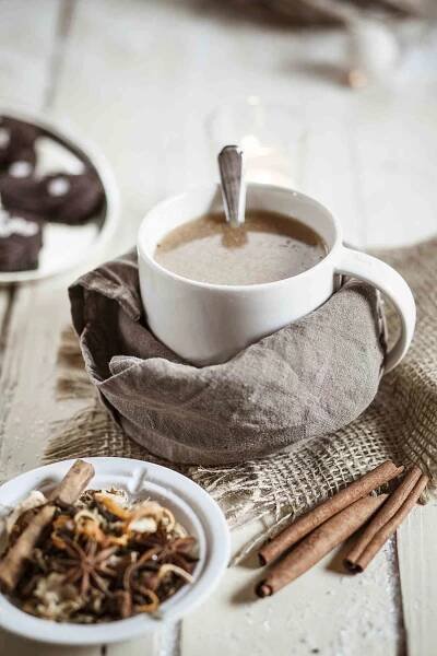 Bowl of Masala chai with almond milk on jute and wood
