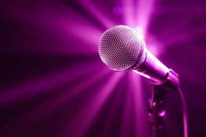 Mikrofon na jevišti s fialovým pozadím — Stock obrázek