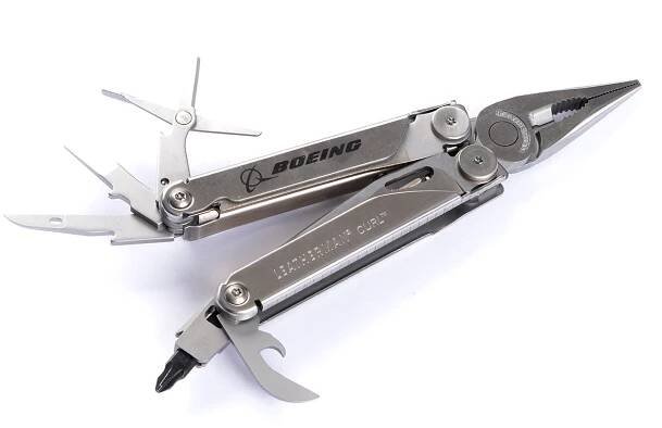 The Boeing Stores silver Boeing Leatherman Curl multitool features extended tools, including pliers, screwdrivers, and a bottle opener. It comes with a convenient pocket clip and displays Boeing branding against a white background.