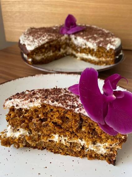 there is a piece of cake with white frosting and purple flowers on the side