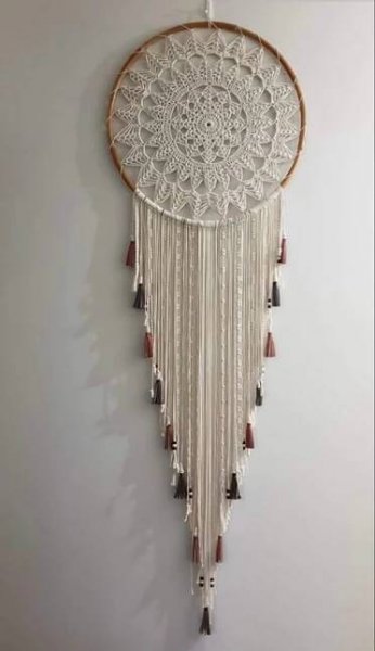 a white wall hanging with beads and tassels