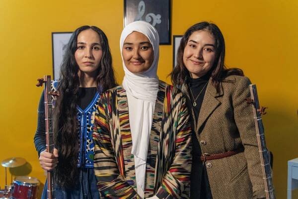 Hayrunisa Yenilmes, center, and Amar Kilich, not pictured, of Alexandria are apprenticing Ajinur Setiwaldi, left, and Subhinur Elemin of Arlington in Uyghur music traditions. The musicians gathered at the monthly bazaar held at the Uyghur Cultural Center in Fairfax to have a lesson on 2/1/25. 
Pat Jarrett/Virginia Humanities