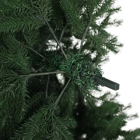 Detail vianočného stromčeka s vetvami a umelou konštrukciou, zelená farba