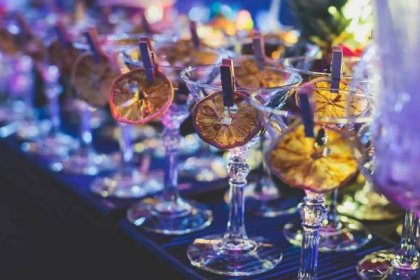 pohled na alkoholové prostředí na cateringovém banketovém stole, řadovou řadu různých barevných alkoholových koktejlů na večírku, martini, vodku a další na zdobeném cateringovém stole - cocktail party - stock snímky, obrázky a fotky
