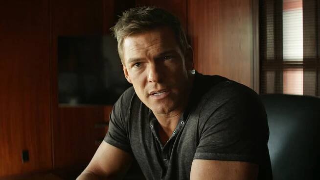 Alan Ritchson's Jack Reacher is seen in closeup as he sits in a study on Reacher