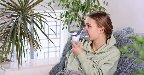 Teenage girl dělá inhalaci s rozprašovačem zařízení. Nemocné dítě drží inhalátor v ruce a dýchá přes inhalátor doma. Fyzikální léčba nachlazení, chřipky a bronchiálního astmatu — Stock záběr