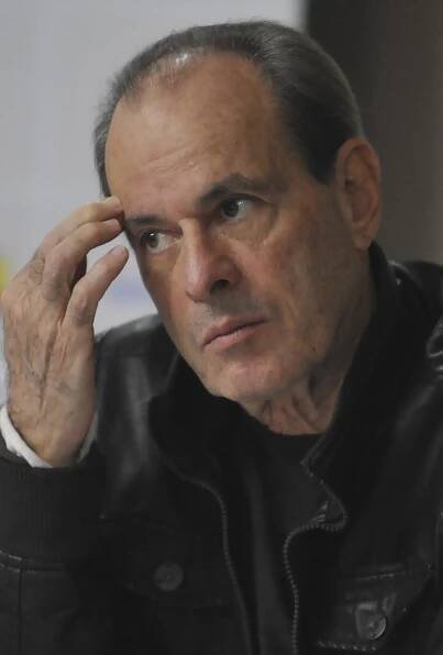 A man is wearing a black jacket and is facing left