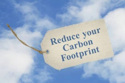 Snižte uhlíkovou stopu zprávy na látkové dárkové značce na modré obloze — Stock obrázek