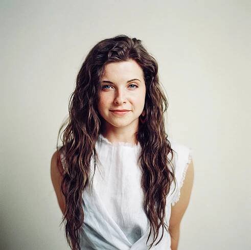 studio portrait of girl in white top against savage seamless tan backdrop on kodak portra 800 film in studio