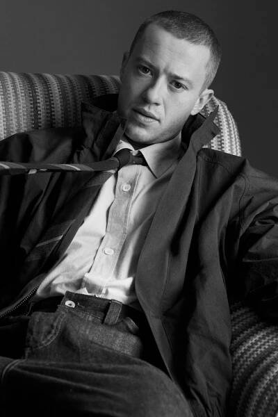 Image may contain Face Head Person Photography Portrait Couch Furniture Clothing Coat Jacket Adult and Sitting