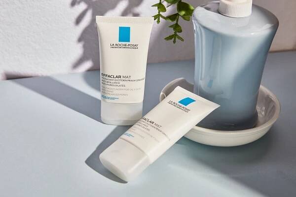 La Roche-Posay Toleriane Double Repair Face Moisturizer on a blue surface next to a soap dispenser
