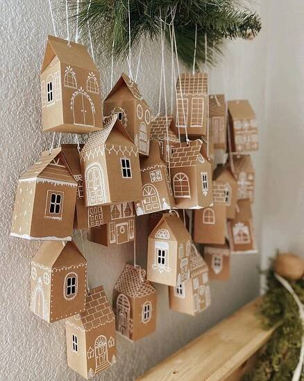 some brown paper houses hanging from a tree