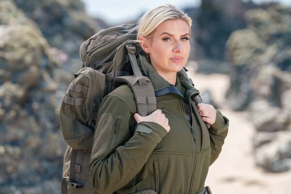 Woman with backpack on beach.
