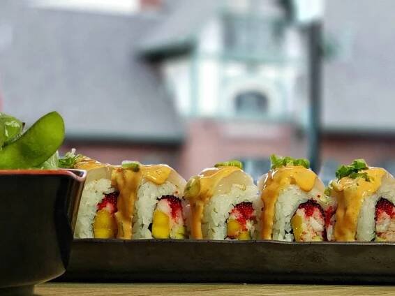 Sushi roll in long black black plate - at favorite restaurants in Flagstaff - Flagstaff historic depot can be seen through window