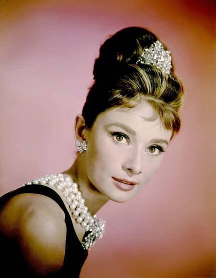 Audrey Hepburn wearing a beehive hairstyle with micro bangs and a tiara